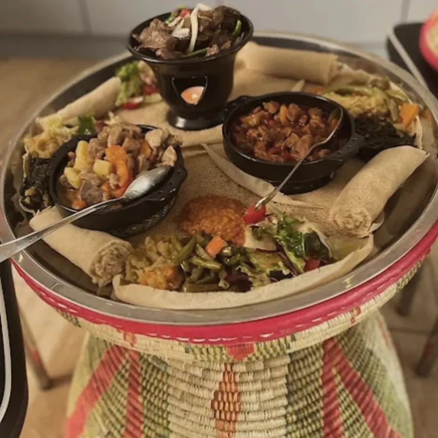Injera met stoofschotels op een geweven mesob-tafel